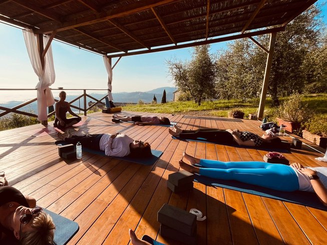 group of people doing on an outdoor deck overlooking the mountains in Tuscany, Italy